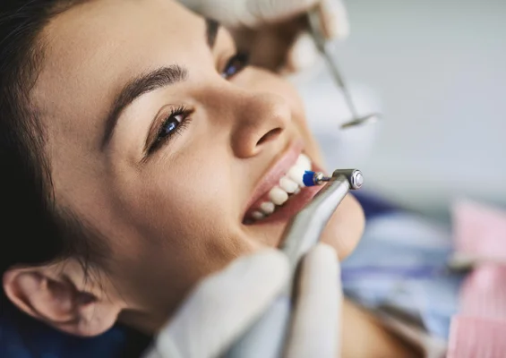 Young child receiving dental examination from dentist in clinical setting.