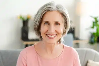 Smiling older woman with healthy teeth after dental implant follow-up care — Dental Care of Mid Florida, Sebring, FL.